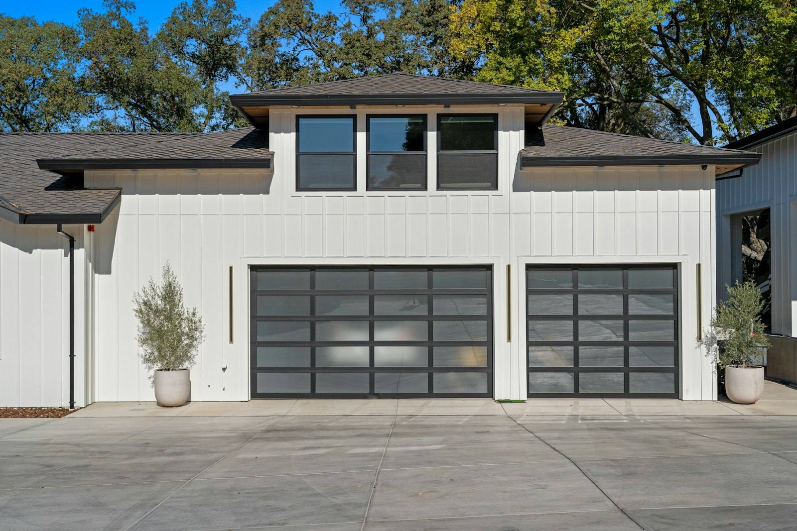 Maison blanche avec deux portes de garage sectionnelles vitrées