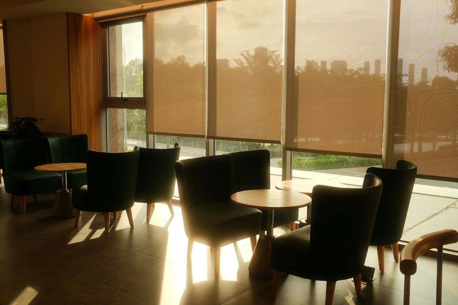 Stores à rouleau filtrant le soleil devant les baies vitrées d'un salon